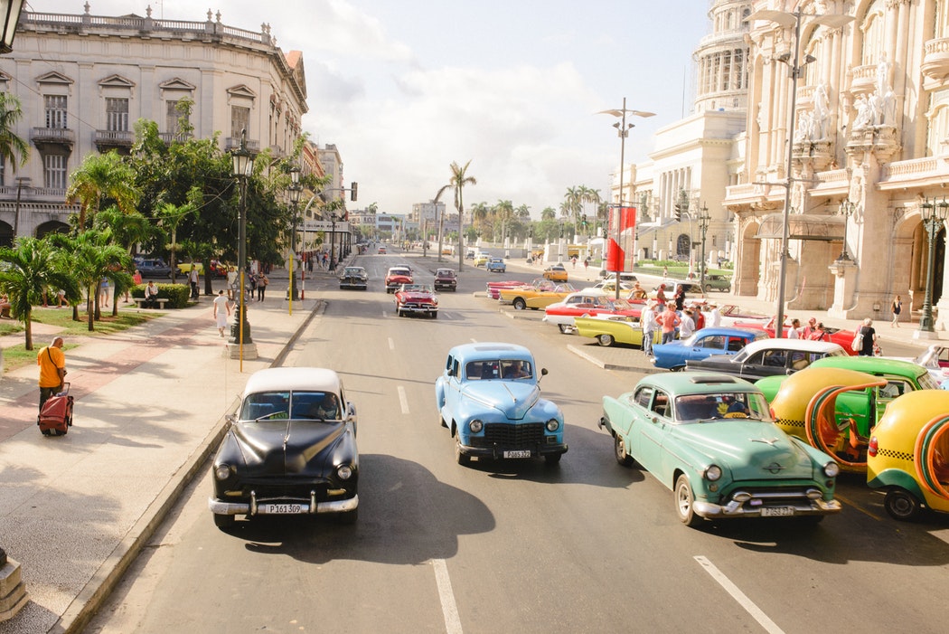 Auf einer mehrspurigen Straße fahren viele Oldtimer.